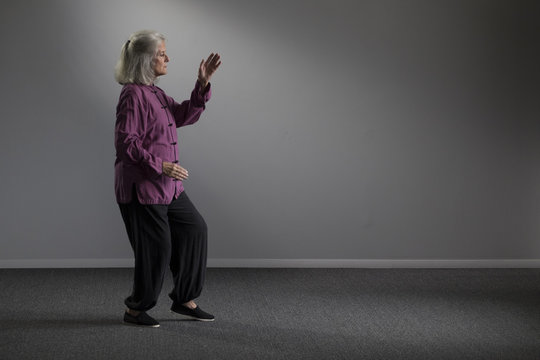 A senior woman doing tai chi