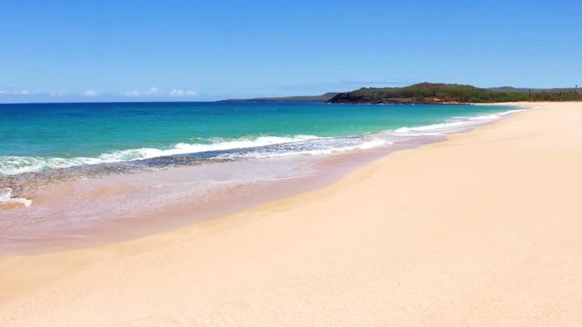 A beautiful white sand beach with clear blue water on a remote beach in Molokai Hawaii..