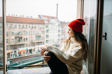 Young hipster woman chilling out on window sill