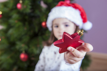 Little girl shows ornaments for Xmas Tree
