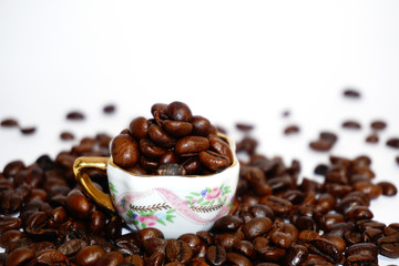 Little cup with coffee beans on grunge background