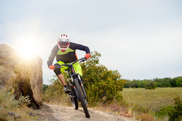 Naklejka premium Professional Cyclist Riding the Bike at the Rocky Trail. Extreme Sport Concept. Space for Text.