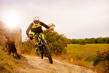Fototapeta na wymiar Professional Cyclist Riding the Bike at the Rocky Trail. Extreme Sport Concept. Space for Text.
