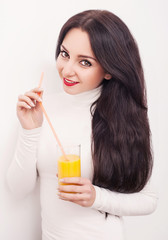Diet. A beautiful young girl who follows the figure, drinking orange juice. The concept of healthy eating. White background.