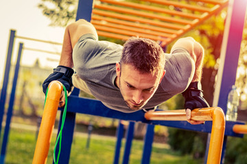 Obraz premium Push-ups - fitness man training push up outside in summer.