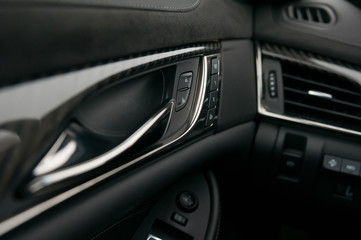 Fototapeta na wymiar Car interior, dashboard, trims, air vent and door handle. Lock and unlock buttons.