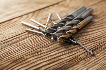 set of different drill bits on wooden background