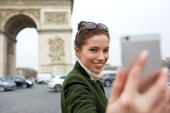 young woman visiting Paris. Triumphal arch. make selfie