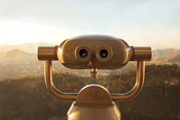 Touristic telescope close-up on the blurred city background