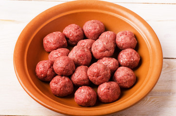 Raw meatballs in plate