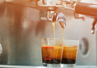 coffee machine preparing espresso and pouring into cups at resta