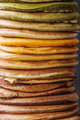 High stack of colorful homemade american ombre chocolate, green tea matcha and turmeric pancakes. Close up. Food background.