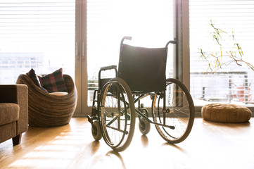 Fototapeta na wymiar Empty wheelchair in living room next to the couch