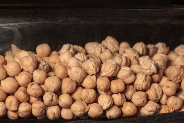  Yellow chickpea in a glass square bottle on a white background 
