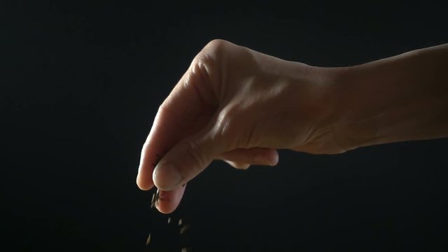 Woman adds some spices on black background. Super slow motion hd video