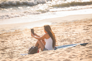 Women making selfie with smartphone on beach