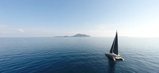 Fototapeten Erstaunliche Aussicht auf Yachtsegeln im offenen Meer an windigen Tagen. Drohnenansicht - Vogelperspektive. - Steigern Sie die Farbverarbeitung. © tirachard