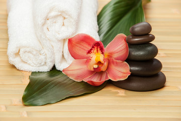 Spa background. White towels on exotic plant, beautiful orchid f
