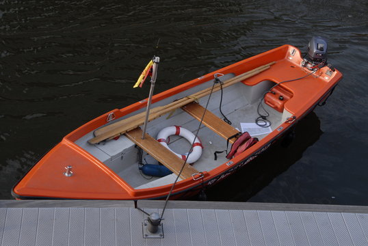 een oranje roeibootje ligt aan de steiger