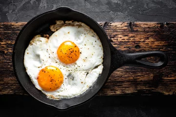 Foto op Plexiglas Spiegeleieren gebakken eieren in zwarte pan