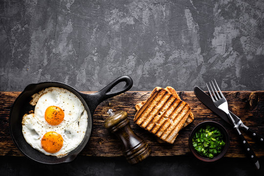 fried eggs on dark background with space for text
