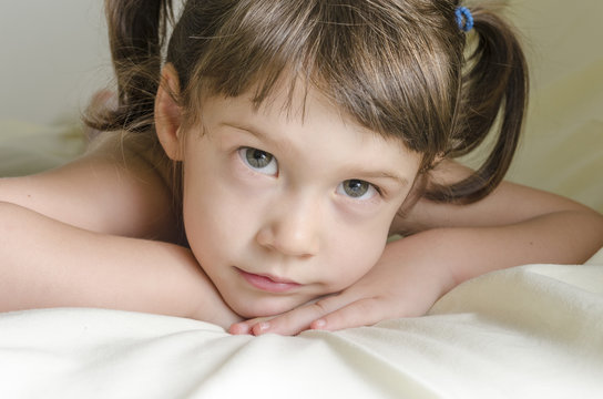 Portrait of a pretty little girl is daydreaming