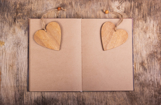 Notepad with blank pages and bookmarks in the shape of a heart. Wooden valentine. Valentine's Day. Copy space