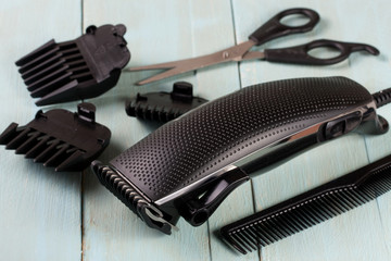 hair trimmer with comb and scissors on the wooden background
