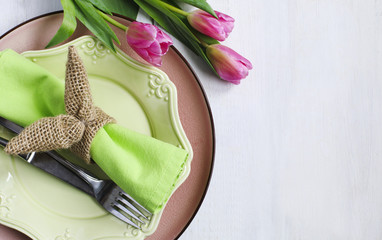 Easter table setting with fresh tulips and festive decoration, top view