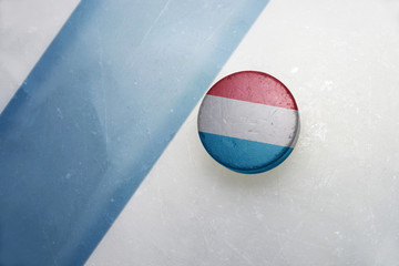 old hockey puck with the national flag of luxembourg.