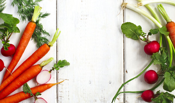 Fototapeta Spring vegetables on wooden background with copy space. 