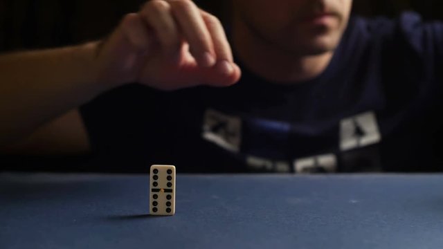 Man set up the domino with hand. Domino effect