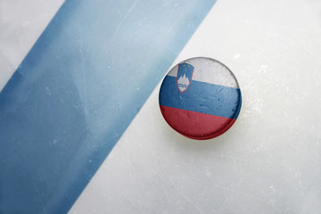 Naklejka premium old hockey puck with the national flag of slovenia.