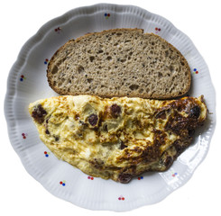Scrambled eggs with fried bacon. French. On a plate with homemade bread on a white background..