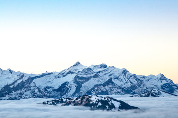 Swiss mountain range with clouds during sunrise near Gstaad, Bernese Oberland, Switzerland