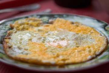 Fried omelette on a plate on tray homemade.