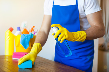 Closeup Of Young Man Wearing Apron Cleaning Kitchen Worktop, set cleaning concept