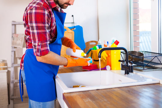 Man makes cleaning the kitchen. Young man washes the dishes. set cleaning concept