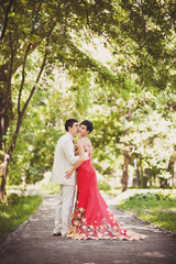 Wedding couple walking in forest. Red wedding concept
