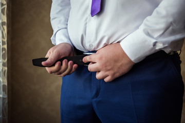 man putting on a belt, Businessman, Politician, man's style, male hands closeup, American businessman, European businessman, a businessman from Asia, People, business, fashion and clothing concept