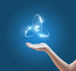 Hand with the atom image on blue background.