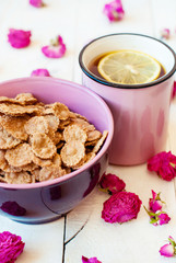 Romantic breakfast with cereal and tea with lemon and dry roses