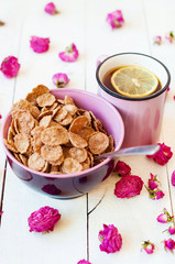 Romantic breakfast with cereal and tea with lemon and dry roses