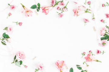 Flowers composition. Frame made of pink flowers and leaves. Top view, flat lay