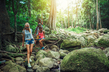 Naklejka na ściany i meble european tourists hiking through jungle in thailand