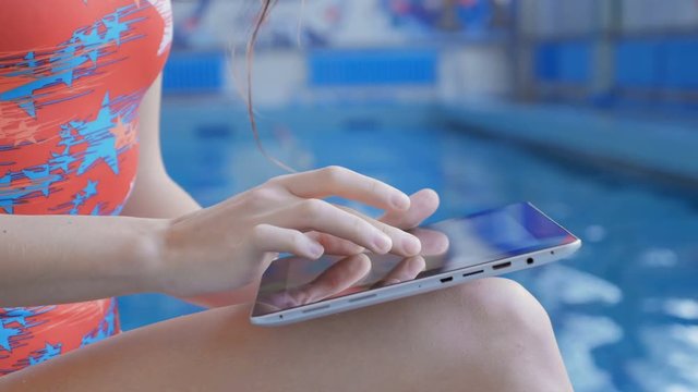 Attractive Girl Athlete is Happy Result. Girl uses a digital tablet
