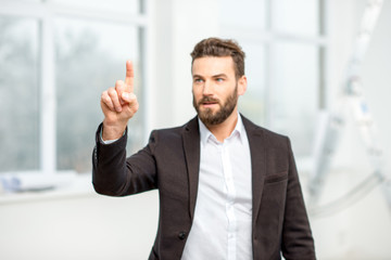Businessman or architect touching virtual screen standing in the room