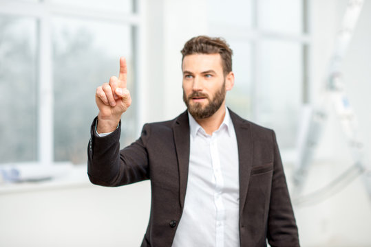 Businessman or architect touching virtual screen standing in the room
