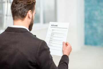 Elegant recruiter reading resume for job hiring in the office