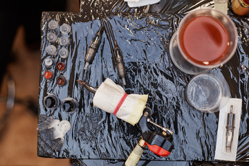 Parts of tattoo machine and bottles with colorful inks
